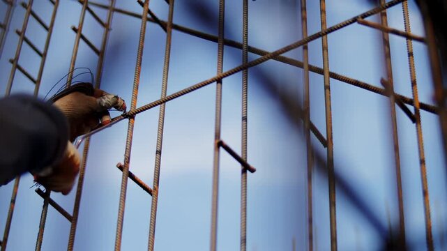 Worker tying steel reinforcement with binding wire