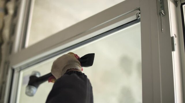 Adjusting window glass inside frame with rubber mallet