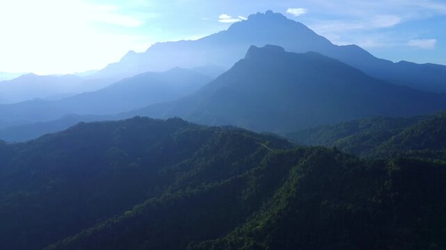 A bird's-eye view of Mount Kinabalu, surrounded by green hills and valleys in Sabah, Borneo. Dawn over Malaysia's highest mountain, 4,095 meters, on the island of Kalimantan. Dron.4K