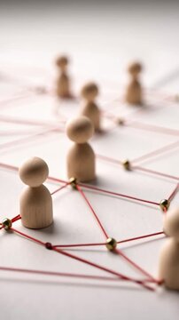 Wooden figure red string human resource employee engagement strategies teamwork connection network collaboration communication relationship link organization structure leadership motivation support