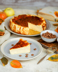 Slice of creamy San Sebastian cheesecake with autumn leaves and chocolate drops