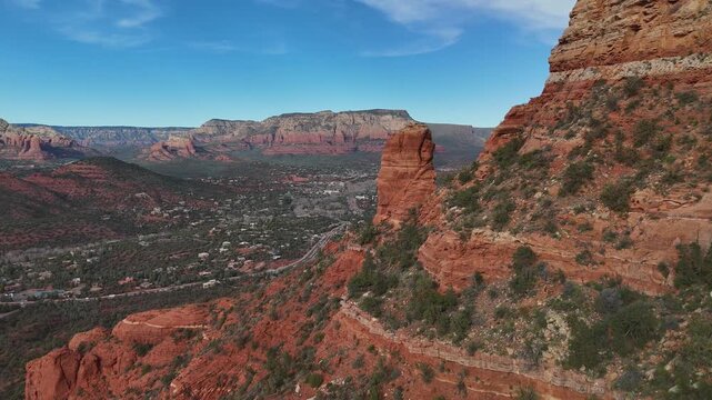 4k drone video revealing large mountain range in sedona arizona with red rocks and lots of folliage
