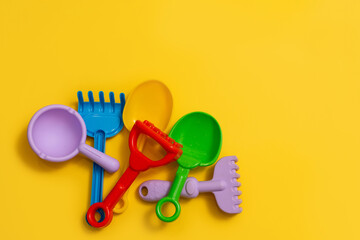 Children's sandbox toys on a yellow isolated background, a place for text, flat lay © KseniaJoyg
