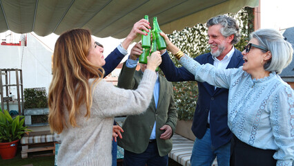 Fototapeta premium Group of friends toasting beer during rooftop party