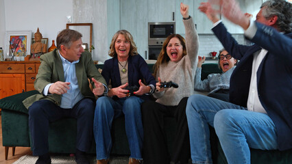 Group of senior friends celebrating video game victory