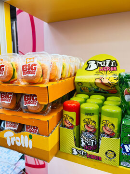 Colorful candy display featuring Brain Licker and Trolli Big Burger packaging on bright orange shelves