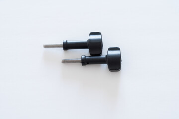 Two Black-head thumb screws horizontally placed on white background