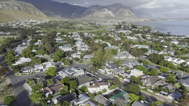 Drone facing east, flies backwards over Hoy's Koppie in the late afternoon along the Garden Route on a sunny day in Hermanus, South Africa