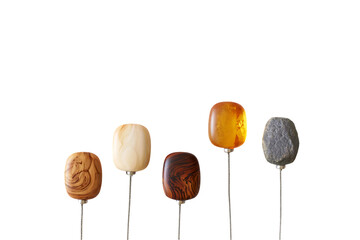 Five wooden and stone earbuds on metal stems against black background isolated on a transparent background