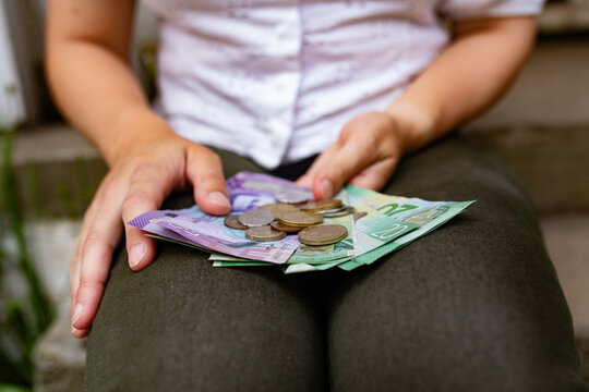 Close-up of a woman's hands holding New Zealand currency