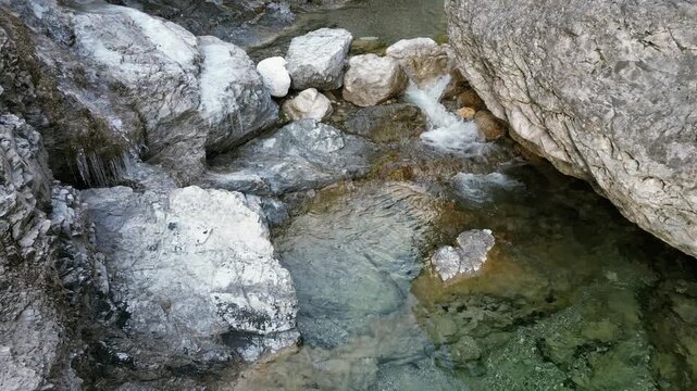 Aerial drone footage over the Susaibes stream near Andreis, Italy: clear water, rocky bed and pristine alpine surroundings. Ideal for nature, travel and scenic stock footage.