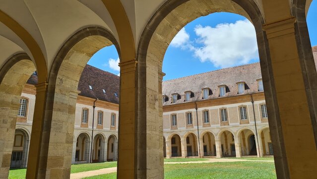 Le Grand Clo&icirc;tre d'une ancienne abbaye bourguignonne vu &agrave; travers les arcades de l'une des galeries lat&eacute;rales