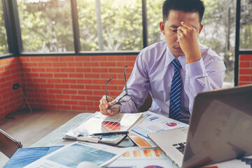 Businessman suffering headache from business disappointed and seriously by bad business results.