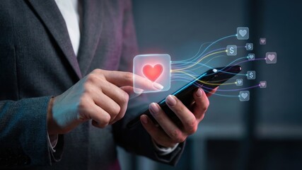 Close up of businesswoman hands using smartphone with futuristic interface pressing heart icon converting social media likes into money and currency symbols in digital marketing.