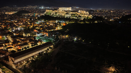 Naklejka premium Aerial drone night shot of amazing illuminated ancient market of Athens or Agora featuring temple of Hephaestus, picturesque Plaka district and Acropolis hill, Attica, Greece