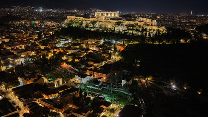Naklejka premium Aerial drone night shot of amazing illuminated ancient market of Athens or Agora featuring temple of Hephaestus, picturesque Plaka district and Acropolis hill, Attica, Greece