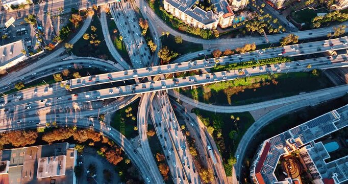 Crazy traffic on the highways of huge interchange. Traffic jams and commuting troubles in modern Los Angeles, California, USA. Top view.