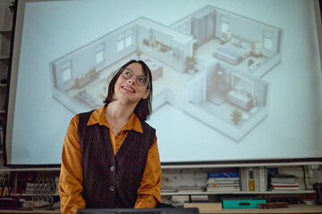 Portrait of young adult Caucasian woman smiling and standing in front of projected architectural...