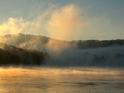 Golden mist over serene river Minho at sunrise near Eiras, O Rosal, Galicia, Spain, January 2025