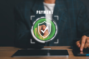 A businessman interacts with a digital shield icon, symbolizing secure online payment and data protection in a modern business setting.