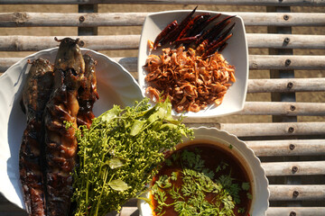 Thai food: Grilled catfish with sweet chili dip and neem leaves.
