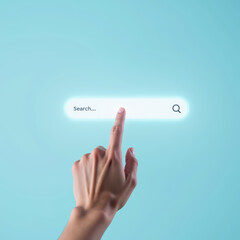 Hand reaching towards glowing search bar on light blue background, symbolizing digital exploration and online searching