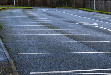 A large car park showing empty parking bays with white lines printed on tarmac. 