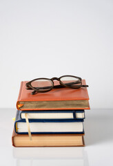 There are dusty glasses on a stack of diaries, leaving some space for text.