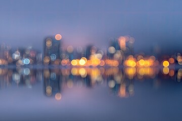 Soft focus urban skyline with glowing lights reflected on calm water