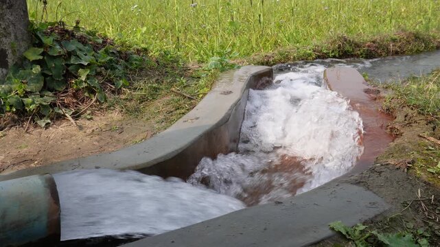 Tubewell pump discharging into irrigation canal for farming