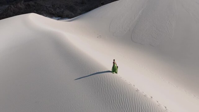Aerial View of a Woman in a Green Dress Walking on Sand Dunes of Socotra Island, Yemen