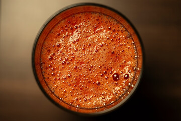 Tomato juice in a glass on a wooden table, top view, copy space