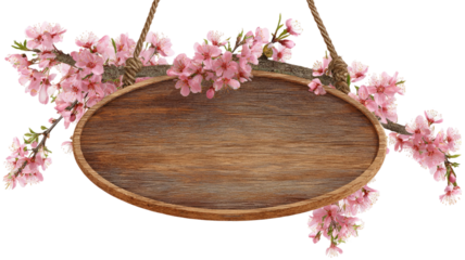 An empty round wooden cutting board frame decorated with spring blossom flowers on a natural brown wood kitchen table texture