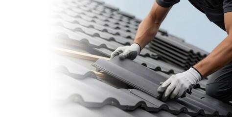Man, a roofer, installing roof tiles on rooftop with new gray ceramic material. Home improvement and construction work concept.