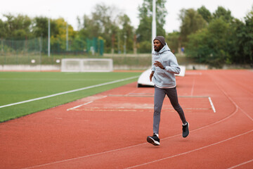 Fototapeta premium African american man running on stadium track
