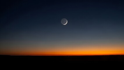 crescent moon in the night sky during sunset