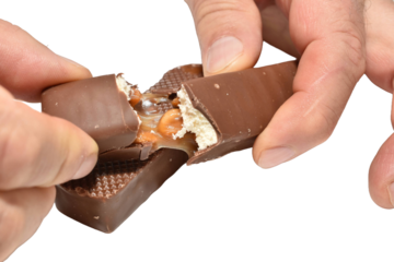 The man broke the chocolate candy. The man is showing the chocolate candy filling.