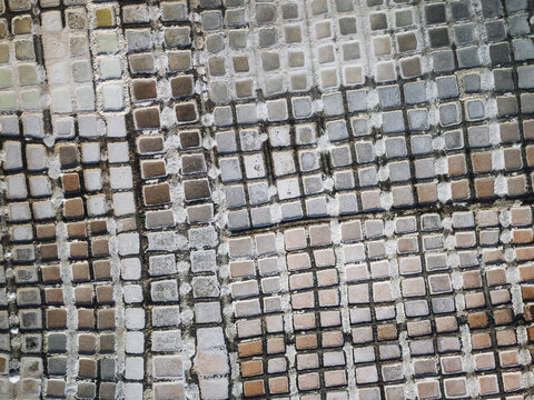 Aerial view of a mosaic pattern of small square tiles in varying shades of brown, gray, and white creating a textured, abstract surface, Daghmar, Oman