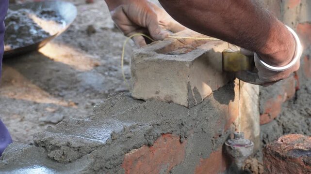 worker laying bricks with mortar in masonry construction