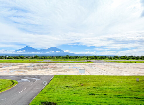 Runway view at Banyuwangi International Airport with a striking panorama of Mount Baluran, Mount Ijen, Mount Raung, and Mount Arjuna lining the horizon.
