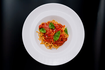 Plato de pasta italiana con salsa y hierbas frescas