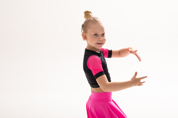 Child dancer with cochlear implant performing arm movement in studio. Copy space. Hearing impairment treatment, auditory training, assistive medical technology, inclusive sport dance, and motor
