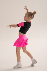 Child dancer with cochlear implant performing arm movement in studio. Hearing impairment treatment, auditory training, assistive medical technology, inclusive sport dance, and motor development