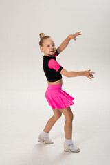 Child dancer with cochlear implant performing arm movement in studio. Hearing impairment treatment, auditory training, assistive medical technology, inclusive sport dance, and motor development
