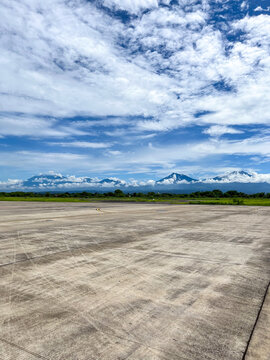 Runway view at Banyuwangi International Airport with a striking panorama of Mount Baluran, Mount Ijen, Mount Raung, and Mount Arjuna lining the horizon.