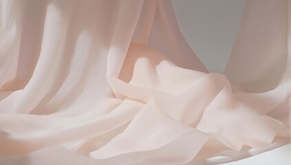 Soft, flowing, light-colored fabric drapes in delicate folds against a backdrop