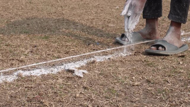 Marking Straight Line on Grassy Field with Chalk Powder