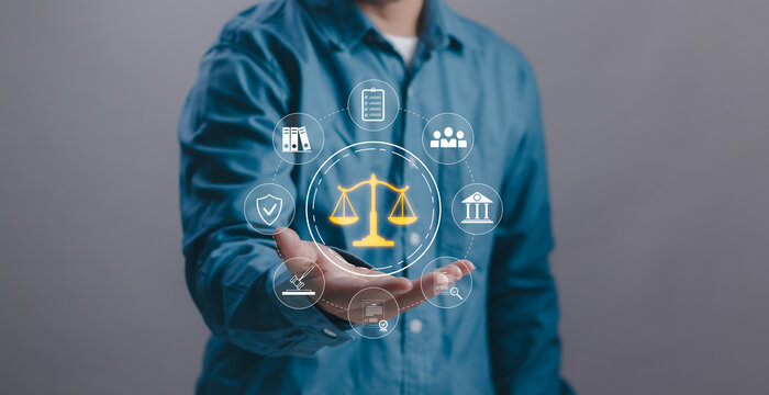 Businessman presenting digital justice scale symbolizing law, legal services, compliance and corporate governance.Concept of business ethics, risk management and professional consulting