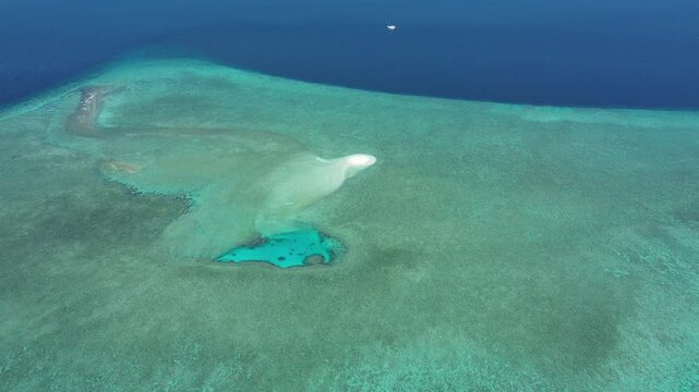 A drone captures sand patches and coral structures just beneath the water's surface near Nil Desperandum, Banda Sea.