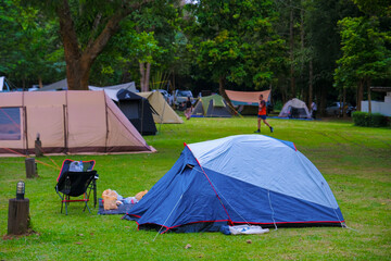 tourist tent camping in mountains at sunset, General view of tent with backpack and hiking equipment in forest, Fun floral and bunting covered canvas yurt tent in open field in California for wedding